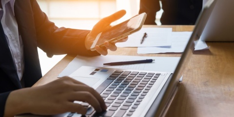 Die Digitalisierung verändert auch den Arbeitsmarkt für Versicherungsfachleute Laptop und Smartphone am Schreibtisch