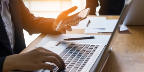 Laptop und Smartphone am Schreibtisch