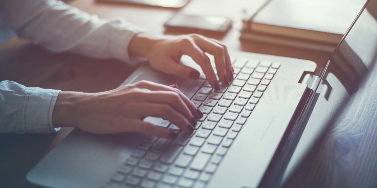 Frau informiert sich am Laptop über Zeugnissprache 